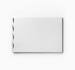 Photo of blank sketchbook or album for drawing on white paper background. Responsive design template. Free space. Top view. Flat lay.