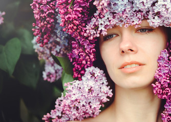 Naklejka premium Outdoor fashion photo of a beautiful young blue-eyed woman. Spring color. beautiful blonde girl in lilac flowers. Perfume with a scent of flowers. Perfumes and beauty