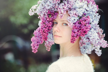 Outdoor fashion photo of a beautiful young blue-eyed woman. Spring color. beautiful blonde girl in lilac flowers. Perfume with a scent of flowers. Perfumes and beauty