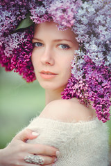 Outdoor fashion photo of a beautiful young blue-eyed woman. Spring color. beautiful blonde girl in lilac flowers. Perfume with a scent of flowers. Perfumes and beauty