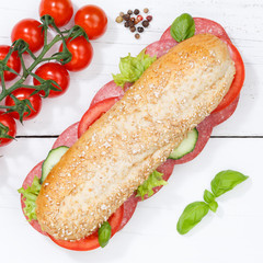Sandwich Baguette Vollkorn Brötchen belegt mit Salami Quadrat von oben auf Holzbrett