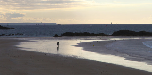 Lonely people on the beach at sunset in Saint-Malo