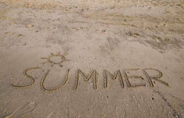 Summer inscription on the sand background