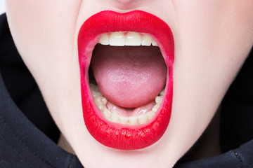 Naklejka premium Mouth of a girl with red lips. Emotion screams. Close-up