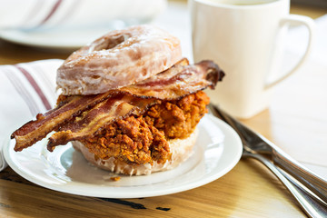 Hot spicy fried chicken and bacon sandwich in a donut