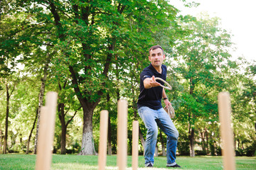 Boy playing a game throwing rings outdoors in summer park