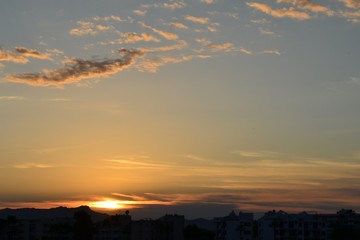 Zachód słońca nad misteczkiem, piękne niebo z kilkoma obłokami - obrazy, fototapety, plakaty