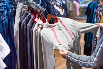 Fototapeta premium Buyer woman chooses clothes in store