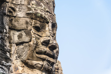 Multiple large faces of the Buddha are carved in to the side of the Unesco World Heritage site of Ankor Thom, Siem Reap, Cambodia