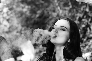 Sexy girl with smartphone smokes hookah