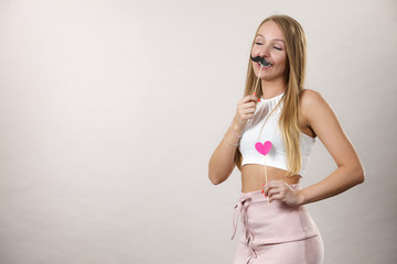Happy woman holding fake moustache on stick