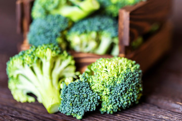 Fresh broccoli in wooden box on wooden surface