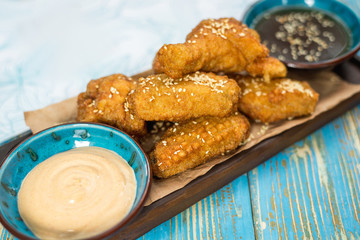 chicken nuggets with sauces on a wooden board