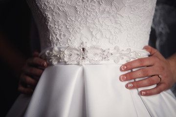 Obraz na płótnie Canvas white wedding dress and bride's hands with manicure
