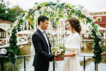 bride and groom outdoors. wedding ceremony. wedding arch..