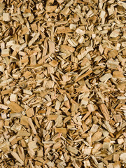 Light brown tan wood chips create abstract rough-textured organic background surface