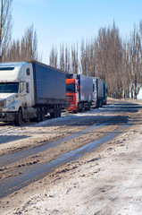 Column of heavy trucks on the winter road.
