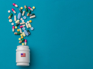 Assorted pharmaceutical medicine pills, tablets and capsules and bottle on green background. Copy space for text