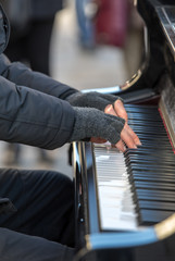 The pianist plays the piano outside in winter