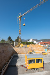Construction site with yellow site trailer and crane