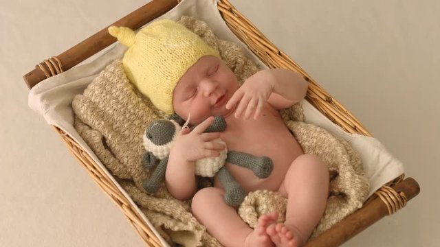 Cute newborn baby doesn't want to sleep lying in a cradle