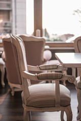 Beige armchair made of wood in restaurant, ancient style