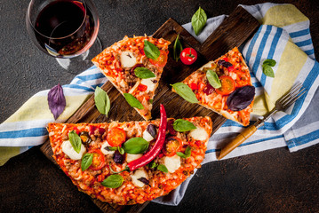 Pizza and red wine on dark background top view copy space