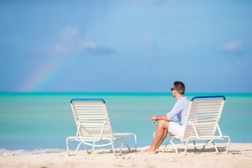 Young man on the beach rest on the sunbed alone outdoor
