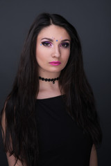 Fototapeta premium Close up face. Young arabic woman in black sexy dress, isolated on gray background