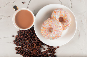 Donuts and coffee with natural milk on a light background. Junk food. Grains of aromatic coffee
