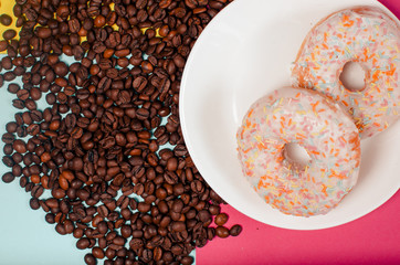 Aromatic roasted black coffee grains and fresh donuts