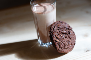 Glass of milk and cookies on a wooden background