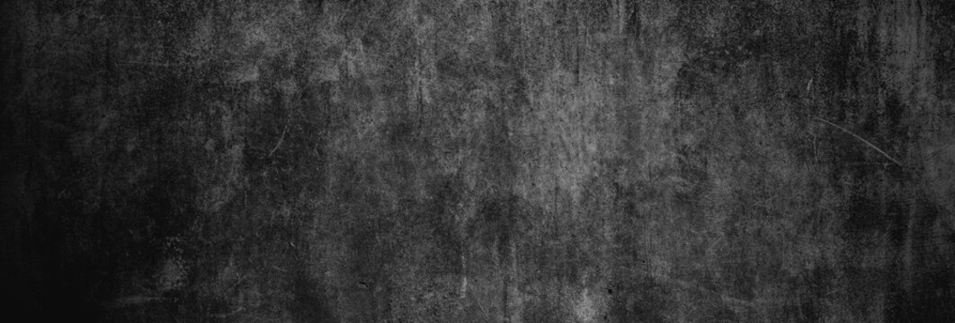 Textur einer fast schwarzen und alten Betonwand als Hintergrund, auf die leichtes Licht f&auml;llt