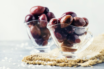 Large greek kalamata olives, gray background, selective focus