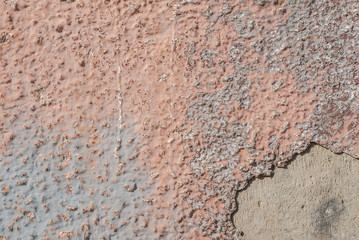 surface of the old wall with exfoliating and falling off paint as a background, pink texture