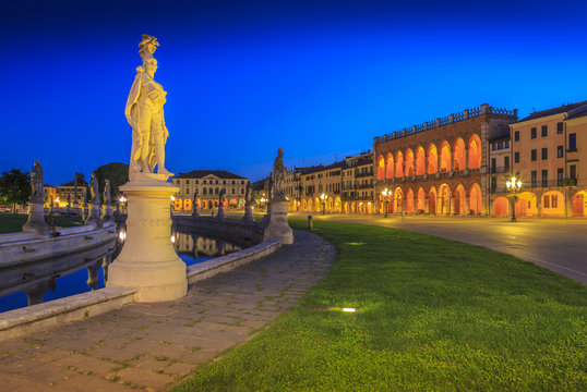 View of statues in Prato della Valle at dusk and Loggia Amulea visible in background, Padua, Veneto