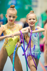 Little adorable gymnasts with medals in rhythmic gymnastics competition