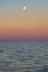 Full moon over sea and sunset with magenta tones