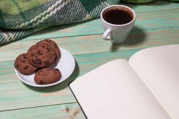 Cup with Hot Tea or Coffee, Warm Plaid, Book on a Wooden Table. with copy space