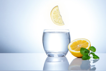 yellow lemons in a glass and splashes of water. Tasty and healthy food. Seasonal drinks