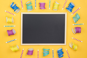 Creative birthday party decoration on yellow background. Top view with frame and space for text.