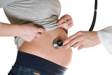 Doctor listens to a pregnant woman with a stethoscope