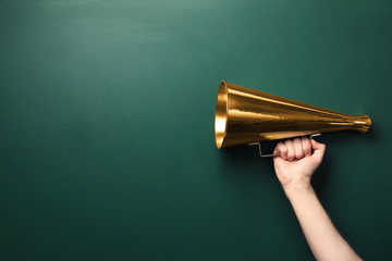 Man holding retro megaphone near chalkboard
