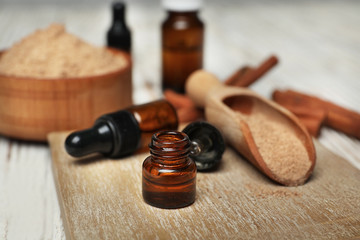 Bottle with cinnamon essential oil on wooden board