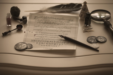 Antique writing materials and antique silver coins on the table