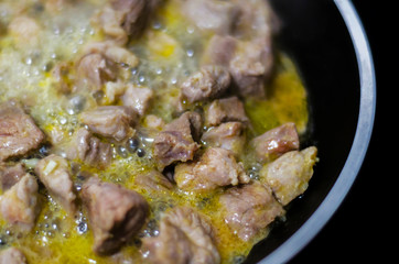 Juicy pork cut into pieces fried in butter, red meat prepared in a pan