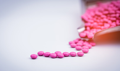 Pile of pink round sugar coated tablets pills on drug tray with copy space. Pills for treatment...