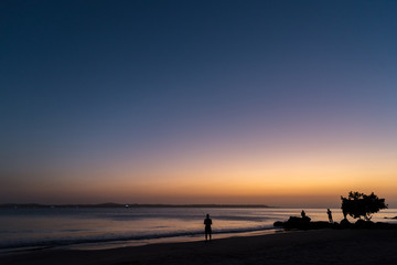 Naklejka na ściany i meble Marine sunset with fishermen on the shore. Colombia