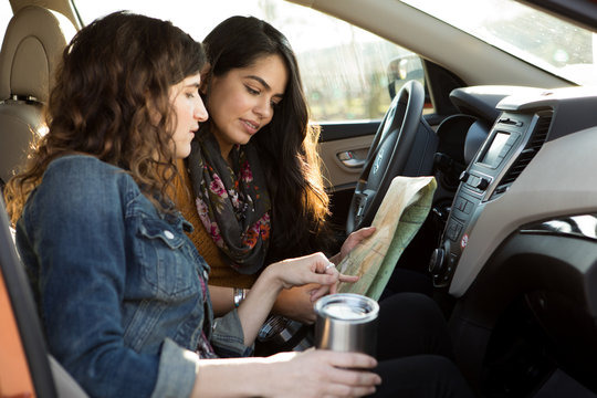 Friends look at map in car