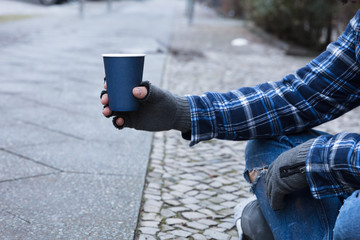 Beggar Holding Disposable Cup